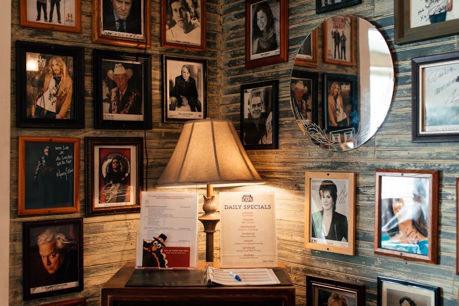 Warm room features celebrity photos on a vintage wall with a cozy lamp illuminating a menu
