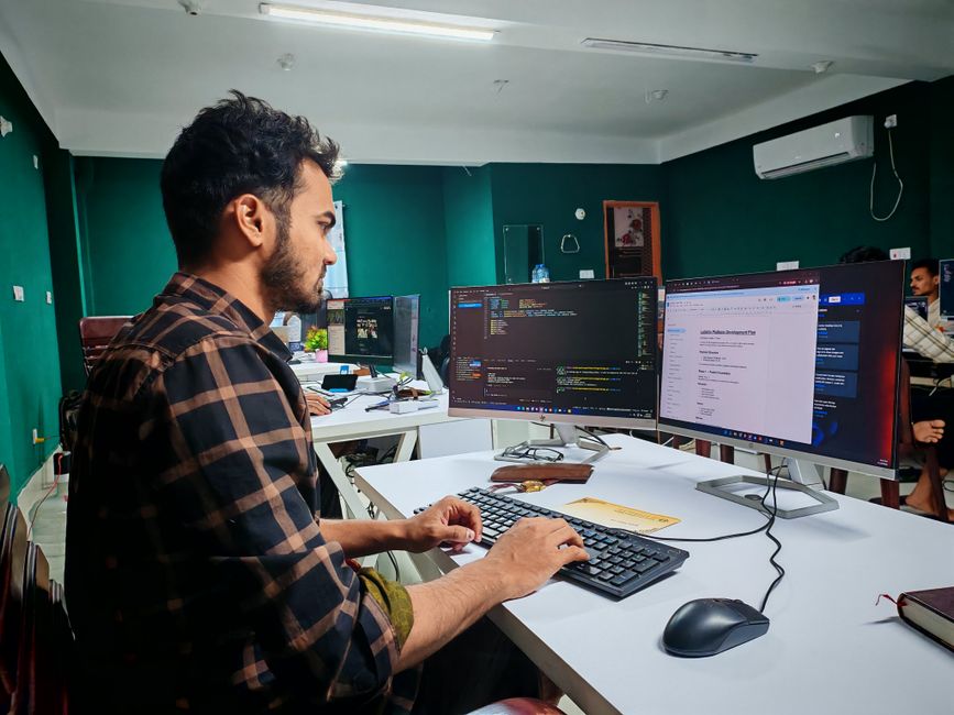 Software developer working on code at a dual monitor setup