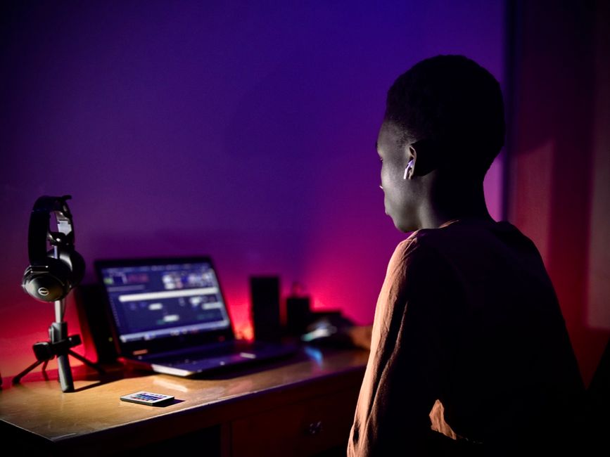 Teenager using laptop with purple ambient lighting